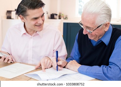 Man Helping Senior Neighbor With Paperwork