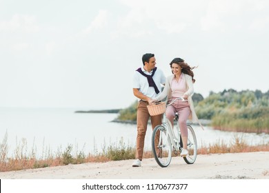 Man Helping Wife Ride Retro Bicycle Stock Photo (Edit Now) 1170677377 pic