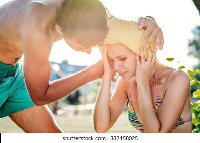 Man Helping Woman In Bikini With Heatstroke, Summer Heat