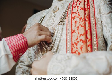 Man Helps Indian Groom To Put His Rich Wedding Clothes With Pearls