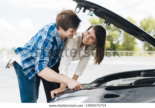 Man helps woman fix her\
car