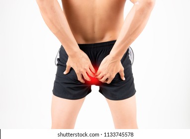 Man With Hemorrhoids Holding His Ass In Pain,Man Holding His Bottom In Pain In A White Background,Man With Hemorrhoids Holding His Butt In Pain,The Pain Caused By Hemorrhoid.