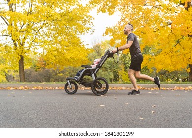 man with her daughter in jogging stroller outside in autumn nature