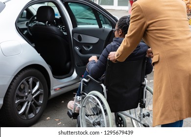 Man With Her Wife Woman Sitting On Wheelchair Moving Towards Car