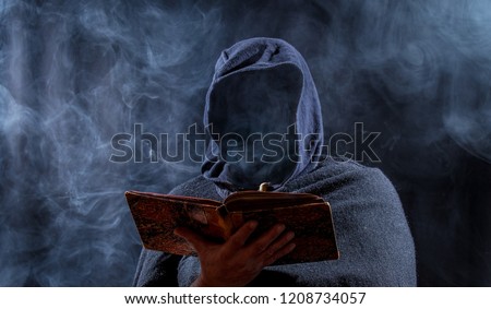 a man hides his face and reads in a book
