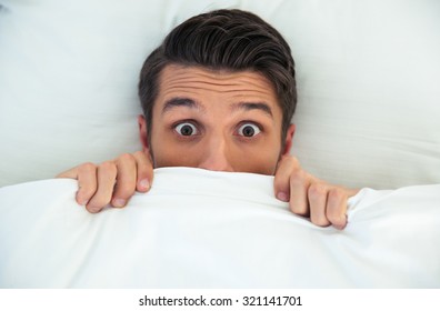 Man Hiding In Bed Under The Blanket At Home