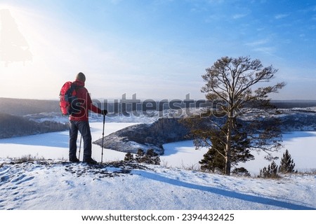 Man hiker hiking by winter. Hikers on the top of hill in a wintry landscape. hiking freedom lifestyle adventure concept 