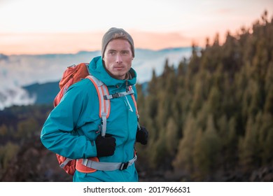 Man hiker hiking in mountain forest wearing cold weather accessories, wind jacket and backpack for camping outdoor. Guy portrait lifestyle.