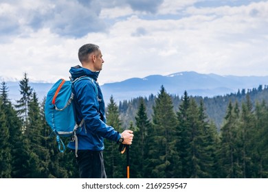 Man hiker hiking in mountain forest wearing cold weather accessories, wind jacket and backpack for camping outdoor. Guy portrait lifestyle - Powered by Shutterstock