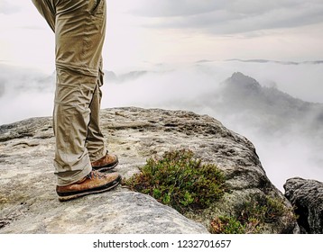 Man Hiker Legs With Windproof Trousers And Hiking Boots On Mountain Peak Rock With A Valley At Background