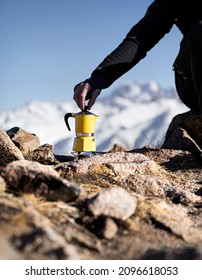 Man Hiker Making Coffee From Yellow Moka Mocha Pot Outdoors In The Snow Winter Mountains. Old Style Coffee Vintage Pot Outdoor Camping