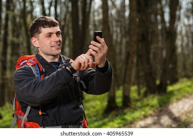 Man Hiker Taking Photo With Smart Phone In Forest