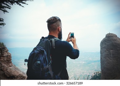 Man Hiker Taking Photo With Smart-phone At Mountain Peak Cliff