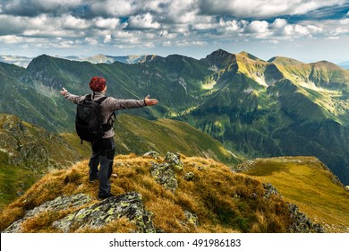 Man Hiking With Backpack Into The Mountains