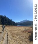 Man hiking in Bend Oregon at Todd Lake with dog and backpack near Mt. Bachelor.