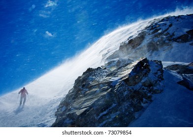 Man Hiking Mountain During Snow Storm With Blue Sky