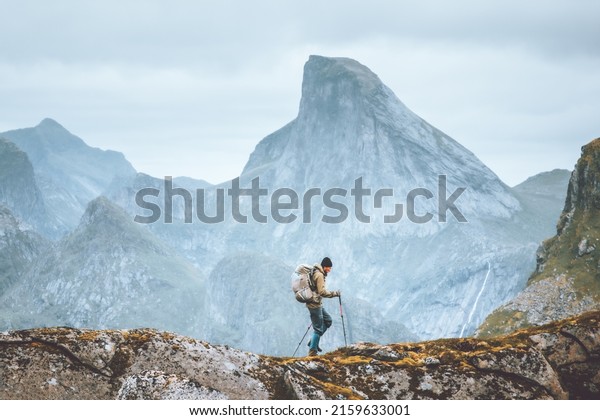 Man\
hiking in mountains traveling solo with backpack outdoor active\
vacations in Norway healthy lifestyle extreme\
sports