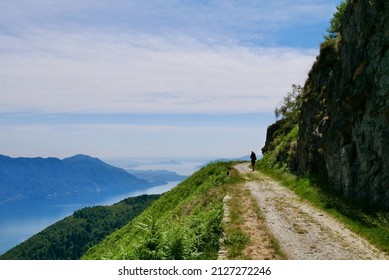 Man Hiking On Old Military Road In The Mountains Above Lake Maggiore Offering Splendid Views. Lombardy, Italy. High Quality Photo