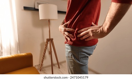 Man with hip, back and sciatica pain at home.
