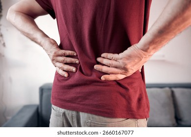 Man with hip, back and sciatica pain at home.