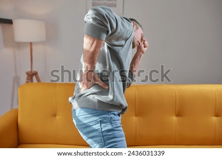 Man with hip, back and sciatica pain at home.