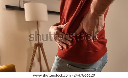 Man with hip, back and sciatica pain at home.
