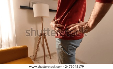 Man with hip, back and sciatica pain at home.
