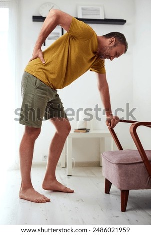 Man with hip, back and sciatica pain at home.