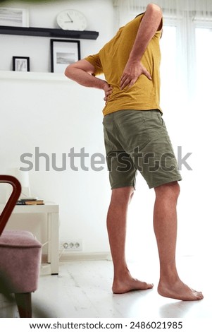 Man with hip, back and sciatica pain at home.