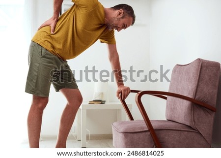 Man with hip, back and sciatica pain at home.