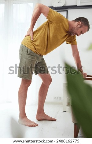 Man with hip, back and sciatica pain at home.