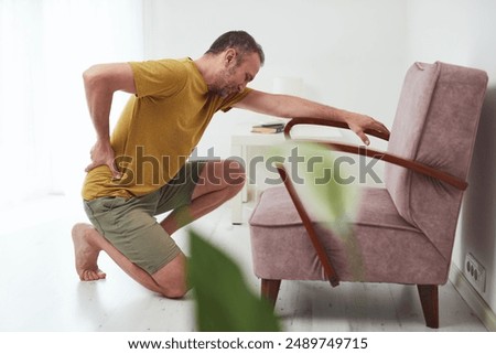 Man with hip, back and sciatica pain at home.