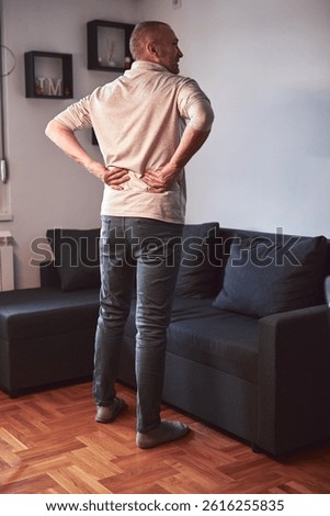 Man with hip, back and sciatica pain at home.