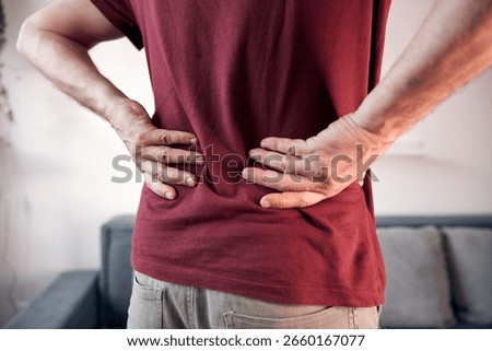 Man with hip, back and sciatica pain at home.