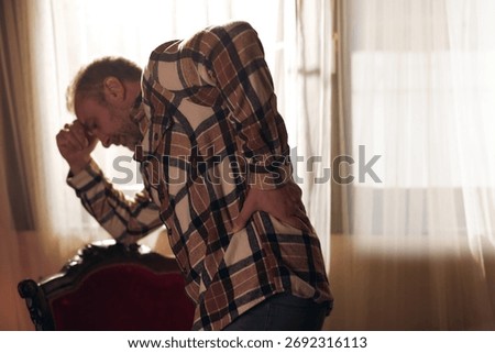 Man with hip, back and sciatica pain at home.
