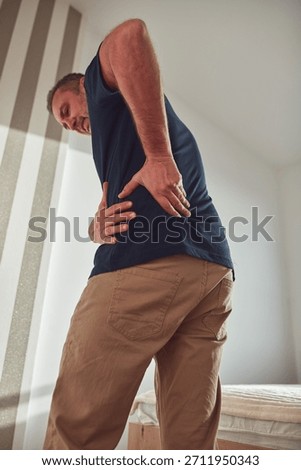 Man with hip, back, spine and sciatica pain at home.