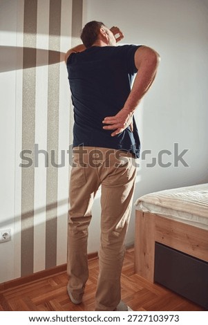 Man with hip, back, spine and sciatica pain at home.