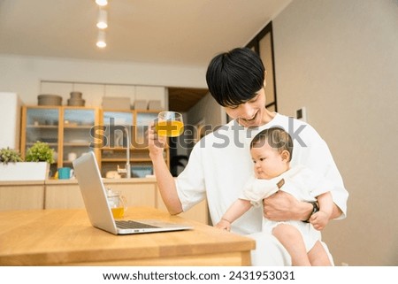 A man in his 20s and 30s who works on a laptop while clinging a baby at the desk in the living room Stock photo © 