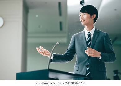 A man in his 30s speaking at a business seminar - Powered by Shutterstock