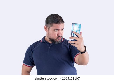 A Man In His 30s Takes A Funny Selfie With His Phone. Making A Hilarious Duck Face. Isolated On A White Background.