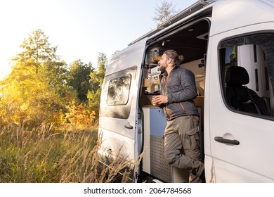 Man And His His Camper Van Standing In An Autumn Scenery