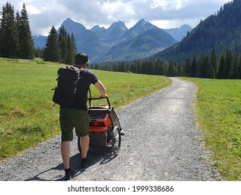 Man with his child in a bicycle trailer walking in the mountains, Slovakia, High Tatras