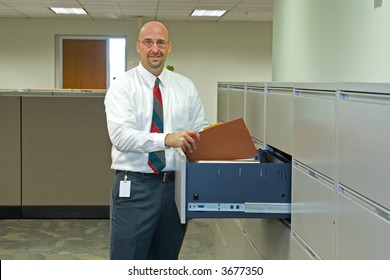 A Man In His Corporate Office Environment, On The Phone And At Work