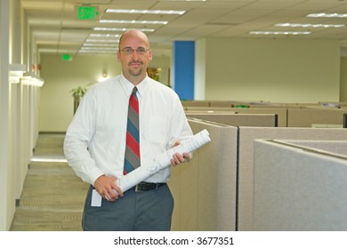 A Man In His Corporate Office Environment, On The Phone And At Work