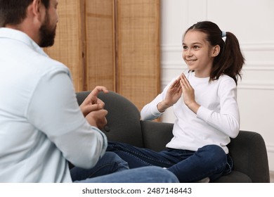 Man and his daughter using sign language for communication at home - Powered by Shutterstock