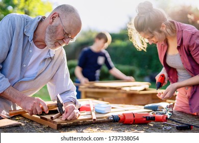 A Man And His Family Are Building Wooden Planters For Their Vegetable Garden