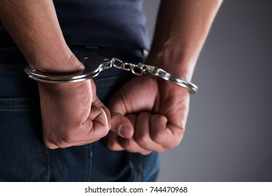 Man with his hands handcuffed in criminal concept