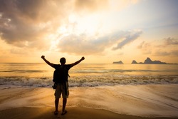 Man With His Hands Up On The Dawn On The Beach
