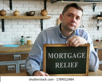 Man At His Home Shows Mortgage Relief Sign.