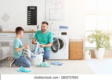 Man and his little son doing laundry at home - Powered by Shutterstock